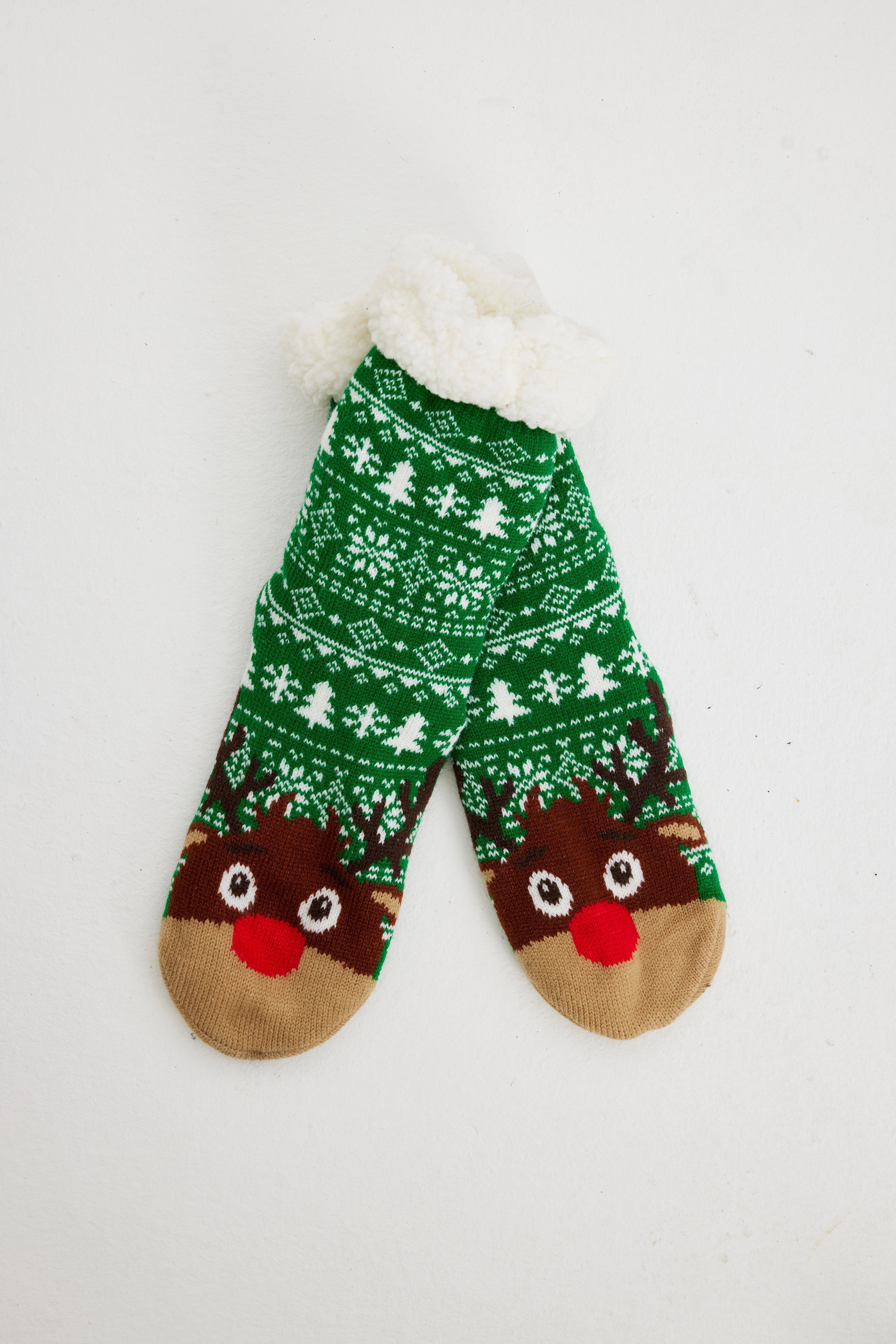 Ein Paar grüne Weihnachtssocken mit einem Rentier darauf.